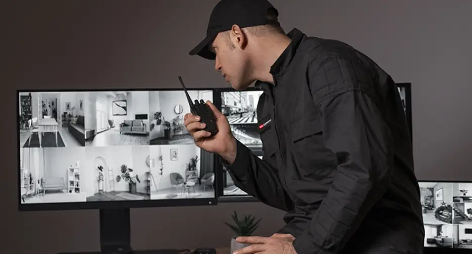 portrait-male-security-guard-with-radio-station-camera-screens